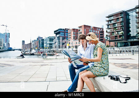 Paar lesen einen Stadtplan an Magellan-Terraces, HafenCity, Hamburg, Deutschland Stockfoto