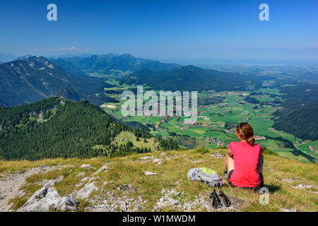 Frau wandern sitzen an Gamsknogel und Suchen in Richtung Inzell, Chiemgauer Alpen im Hintergrund, Gamsknogel, Chiemgauer Alpen, Oberbayern, Bayern, Deutschland Stockfoto