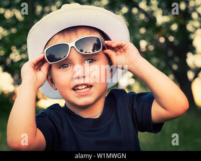 Porträt einer fröhlichen kleinen Jungen in Sonnenbrille Stockfoto