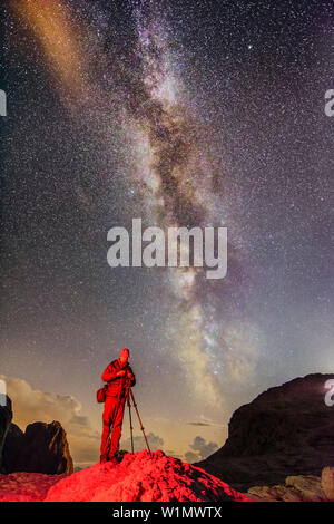 Fotograf steht auf Rock unter Stary Sky mit der Milchstraße, Pala, Dolomiten, UNESCO Weltnaturerbe Dolomiten, Trentino, Italien Stockfoto