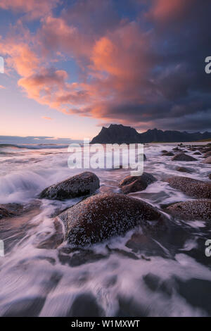 Sonnenuntergang über den Lofoten Insel Vestvågøy mit Blick auf den Strand von Utakleiv mit Wellen im Vordergrund, Norwegen, Skandinavien Stockfoto