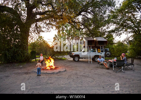 Familie sitzt um Lagerfeuer, Nata, Nxai Pan National Park, Botswana Stockfoto