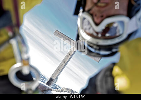 Snowboarder, Abseilen, Gipfelkreuz im Hintergrund, Oberjoch, Bad Hindelang, Bayern, Deutschland Stockfoto