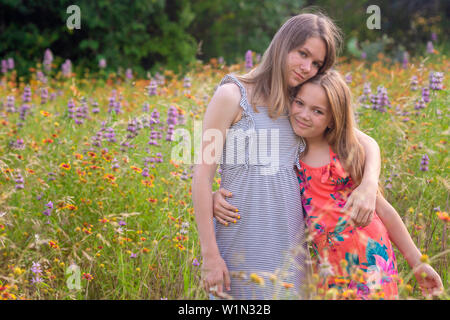 Schwestern in Wildblumen in Park Stockfoto