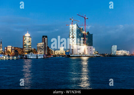 Blick über die Elbe zur Hafencity mit der Elbphilharmonie am Abend, Hamburg, Deutschland Stockfoto