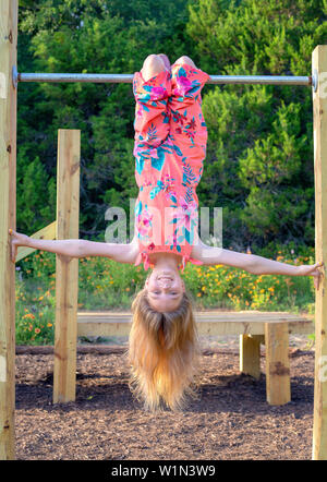 Mädchen hing kopfüber im Park Stockfoto