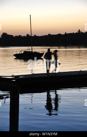 Paar tanzen auf einem Steg am Ammersee bei Sonnenuntergang, Herrsching, Oberbayern, Deutschland, Europa Stockfoto