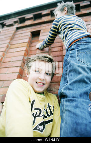 Junge, Freund eines Bunk-up über eine Wand Stockfoto
