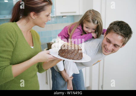 Junge Familie mit einem Schokoladenkuchen in einem einheimischen Küche, München, Deutschland Stockfoto