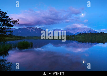 Vollmond im See Barmsee, Blick auf die Soierngruppe und Karwendel, Werdenfelser Land, Bayern, Deutschland widerspiegelt Stockfoto