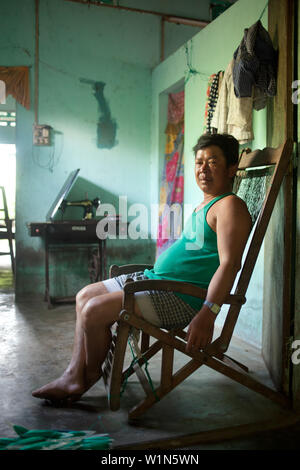 Ein Südvietnamesischen Mann sitzt in seinem Wohnzimmer Stockfoto
