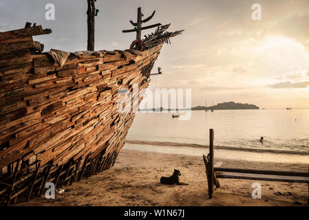 Hund den Sonnenuntergang genießen Neben der so genannten Hippie Bar in der Form eines Piratenschiffes in Buffalo Bay Ao Khao Kwai, Ko Phayam, Andamac Küste, Thailand Stockfoto