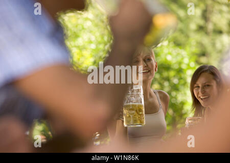 Flirten im Biergarten, zwei junge Frauen und zwei Männer flirten im Biergarten, Starnberger See, Bayern, Deutschland Stockfoto