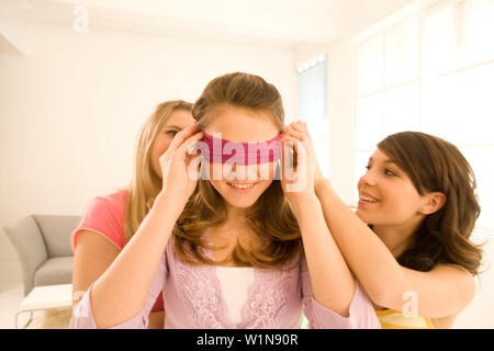 Junge Mädchen (14-16) spielen die Blinden Bluff Stockfoto