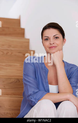 Frau sitzt auf der Treppe, 30 Jahre Stockfoto