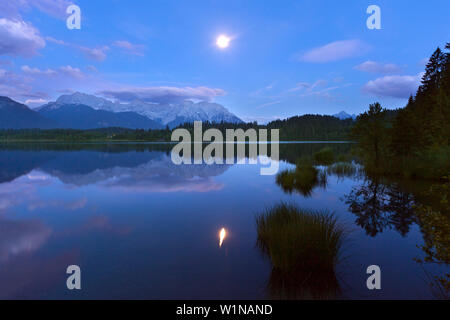 Vollmond im See Barmsee, Blick auf die Soierngruppe und Karwendel, Werdenfelser Land, Bayern, Deutschland widerspiegelt Stockfoto