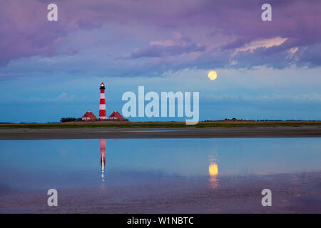 Leuchtturm, Gewitterwolken und Mond im Wasser widerspiegelt, Leuchtturm Westerhever, Eiderstedt, Schleswig-Holstein, Deutschland Stockfoto