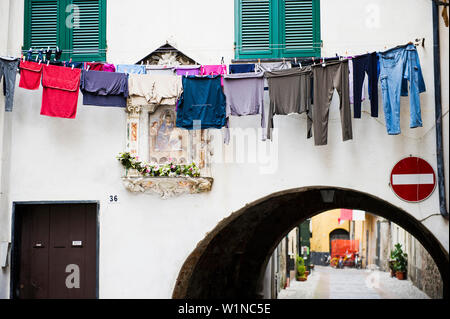 Waschmaschine über eine Gasse, Albenga, Provinz von Savona hängend, Riviera di Ponente, Ligurien, Italien Stockfoto