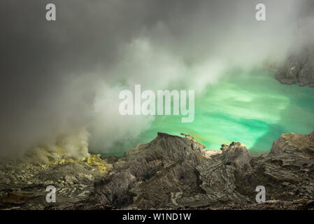 Blau säure See mit Schwefel Gase des aktiven Vulkans Ijen während des Tages. Sonne am See und Umgebung, Ost Java, Ijen Vulkan, Ind Stockfoto