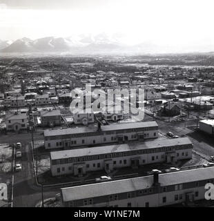 1950er Jahre, historischer Blick aus der Luft über die Häuser und die umliegenden Straßen in einem Teil der Stadt Anchorage, Alaska, USA. Gesehen in der Ferne das Chugach Gebirge. Stockfoto