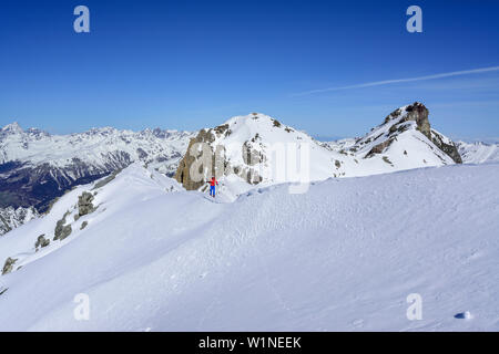 Frau back-country skiing aufsteigend auf Grat in Richtung Piz Lischana, Sesvenna Piz Lischana, Alpen, Engadin, Graubünden, Schweiz Stockfoto