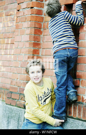 Junge, Freund eines Bunk-up über eine Wand Stockfoto