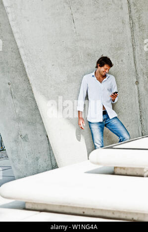 Mitte der erwachsene Mann mit Handy, HafenCity, Hamburg, Deutschland Stockfoto