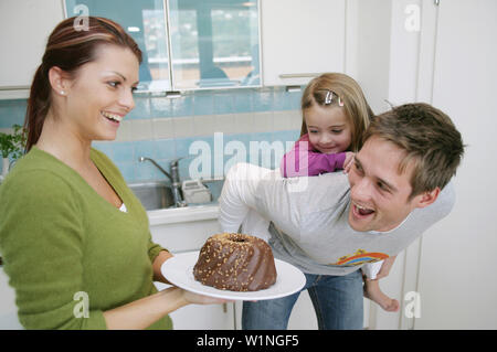 Junge Familie mit einem Schokoladenkuchen in einem einheimischen Küche, München, Deutschland Stockfoto