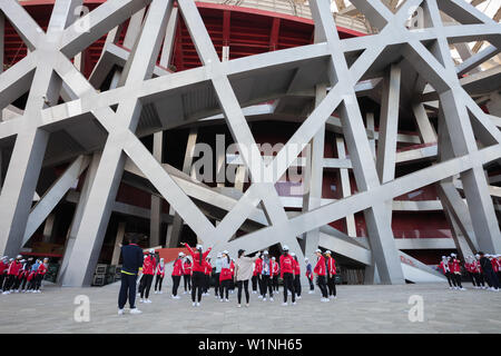 Zug Gruppe junger Mädchen, bevor die Leistung an der Vorderseite der Bird's Nest Stadion in Olympic Park, Peking, China Stockfoto