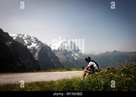 Radfahrer eine Pause auf einem Pass, Eiger und Mönch im Hintergrund, Abstieg vom Grosse Scheidegg nach Grindelwald, Berner Oberland, Switzerl Stockfoto