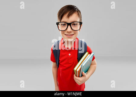 Smiling Student boy in Gläsern mit Büchern und Tasche Stockfoto