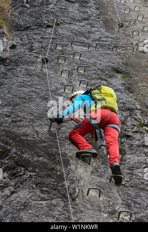 Frau klettern den Klettersteig La Resgia, Engadin, Graubünden, Schweiz Stockfoto