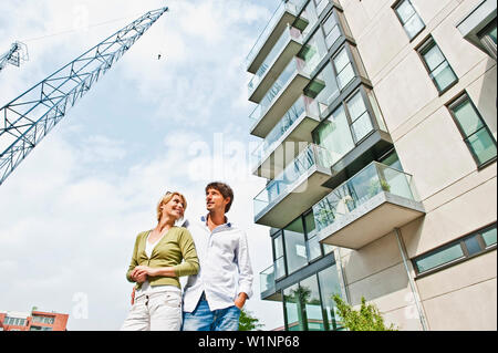 Paar in der Nähe von modernes Apartmentgebäude, HafenCity, Hamburg, Deutschland Stockfoto