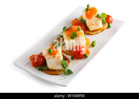 Fisch mit Gemüse auf weiße Platte. Auf weissem Hintergrund. Stockfoto