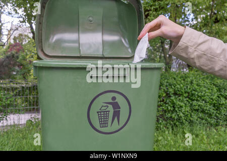 Frau Hand werfen zerknittertes Papier in Fach Stockfoto