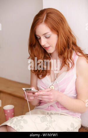 Junge Frau tragbaren MP3-Player anhören Stockfoto