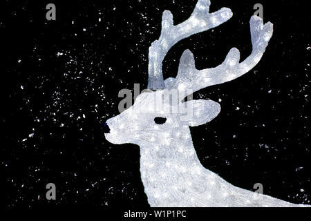 Weihnachtsbeleuchtung in der Form von Rentieren und Schnee. Stockfoto