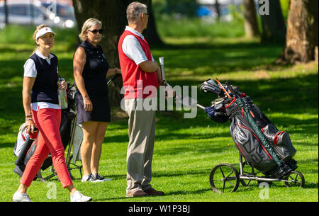Braunschweig, Deutschland, Mai 18., 2019: Ältere Golfspieler stehen mit ihren Karren auf dem Rasen der Golfplatz Stockfoto