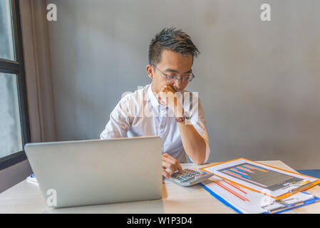 Brille Finanz Buchhalter mit Taschenrechner, die Analyse von Graphen Dokument Stockfoto