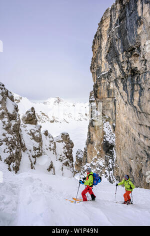 Zwei Personen backcountry Skiing aufsteigend durch einen Canyon zu Puezspitze, Puezspitze, Naturpark Puez-Geisler, UNESCO Weltnaturerbe Dolomiten, Stockfoto