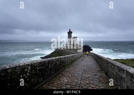 Frau in gelb Regenjacke zu fuß auf die brücke zu Phare du Diable, Brest, Brest, im Département Finistère, Bretagne - Bretagne, Frankreich, Europa Stockfoto