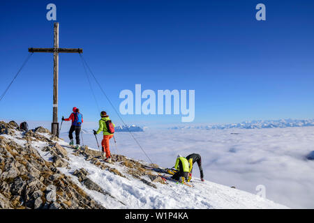 Zwei Frauen backcountry Skiing aufsteigend in Richtung Hintere Sonnwendjoch, Nebel im Tal, Hintere Sonnwendjoch, Bayerische Alpen, Tirol, Österreich Stockfoto