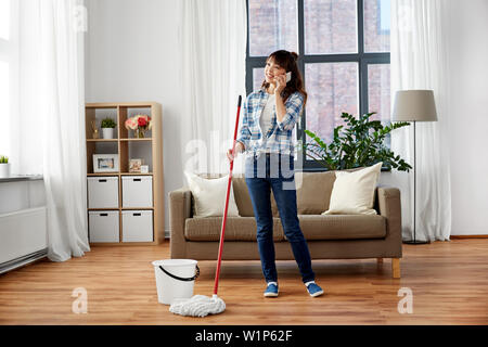 Asiatische Frau mit Smartphone wischen Etage zu Hause Stockfoto