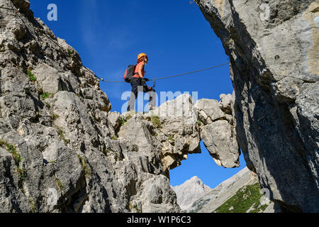 Frau steigt über die Bögen am Klettersteig bettelwurf, Absamer Klettersteig, bettelwurf, Karwendel, Tirol, Österreich Stockfoto