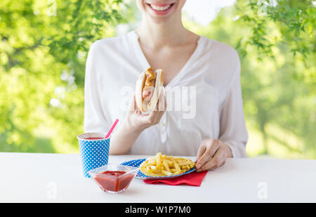 Nahaufnahme von Frau essen Würstchen und Pommes frites Stockfoto