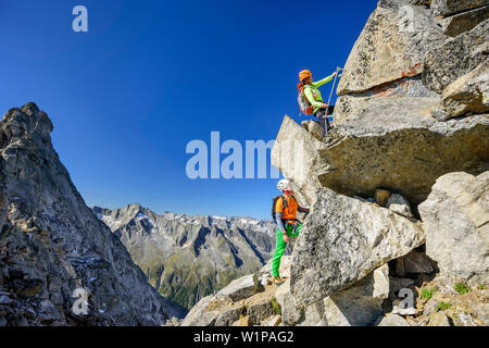 Mann und Frau klettern auf fixed-rope Route in Richtung Richterspitze, Richterspitze, Reichenspitze Gruppe, Zillertaler Alpen, Tirol, Österreich Stockfoto