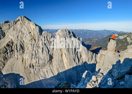 Mann sitzt auf Rock spire und Suchen in Richtung Wand des hinteren Karlspitze, von der Hinteren Goinger Halt, Wilder Kaiser, Kaiser, Tirol, Österreich Stockfoto