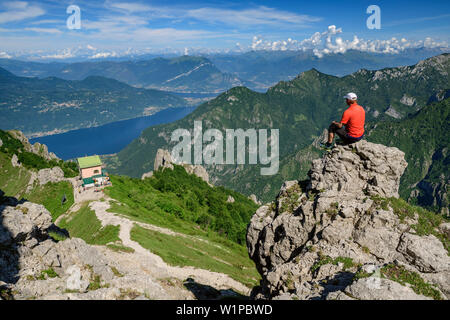 Menschen wandern auf Band und Suchen in Richtung Hütte Rifugio Rosalba und den See Lago di Como, von Grignetta, bergamasque Grigna, Alpen, Lombardei, Italien Stockfoto