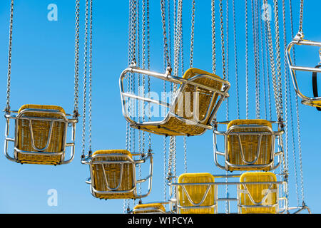 Gelbe Sitze von der klassischen Kette Karussell, Hamburg, Deutschland Stockfoto
