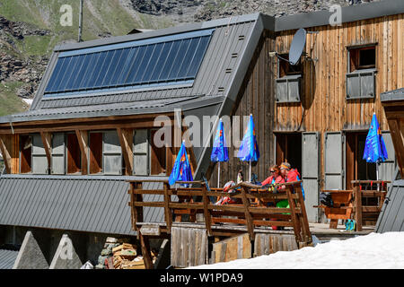 Mann und Frau wandern sitzen am Hut Zuflucht Viso, Giro di Monte Viso, Monte Viso, Monviso, Cottischen Alpen, Frankreich Stockfoto